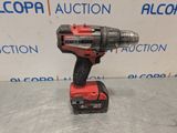 a red cordless drill is sitting on a table in front of a sign