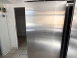 a stainless steel refrigerator in a kitchen with tile flooring