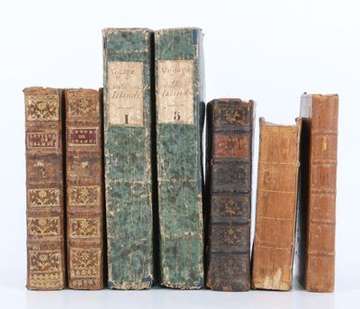plusieurs vieux livres sont empilés sur une surface blanche