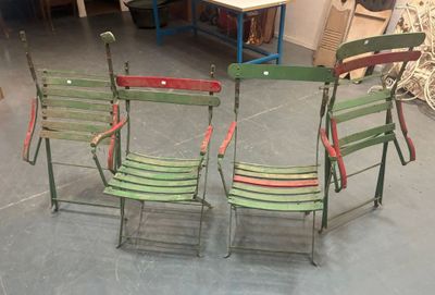 three green and red folding chairs sitting in a room next to a table
