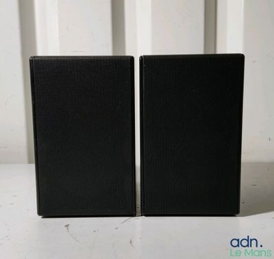 une paire d'enceintes noires posées l'une à côté de l'autre sur une table