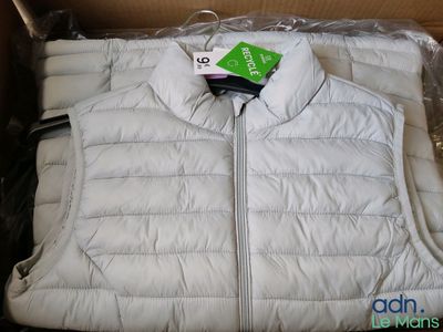 une veste blanche dans une boîte sur laquelle est accrochée une étiquette