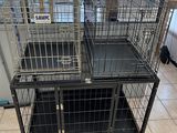 two black cages are stacked on top of each other in a room