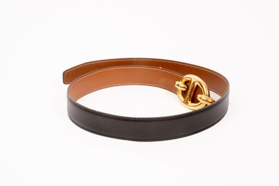 un gros plan sur une ceinture noire et marron dotée d'une boucle dorée