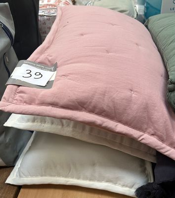 a pile of pillows on a table with a price tag on it