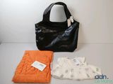 un sac à main, un pull et une couverture posés sur une table