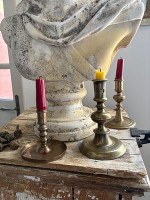 a bust of a woman sitting on top of a table with candles