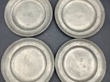 quatre assiettes en argent posées les unes à côté des autres sur une table