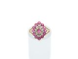 a close up of a pink and white diamond ring on a white surface