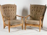 pair of mid - century danish lounge chairs with upholstered cushions