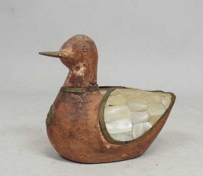 une image représentant un petit canard en bois posé sur une table