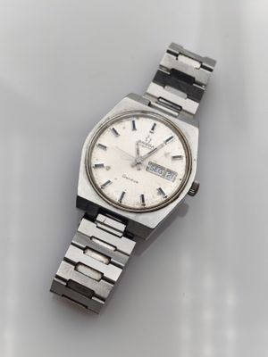 a close up of a watch on a table with a white background