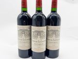 trois bouteilles de vin rouge posées l'une à côté de l'autre sur une surface blanche