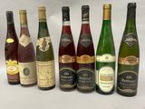 several bottles of wine are lined up on a white surface