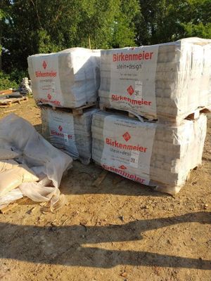 une pile de cartons posée par terre, dans la poussière