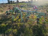 a green plow that is sitting in the grass