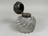 a glass vase with a lid on a white table