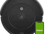a robot vacuum cleaner with a phone next to it