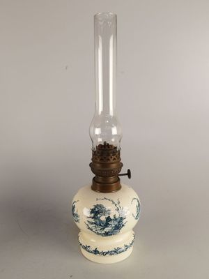 an old fashioned oil lamp with a blue and white design on it