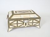 une boîte blanche et dorée posée sur une surface blanche