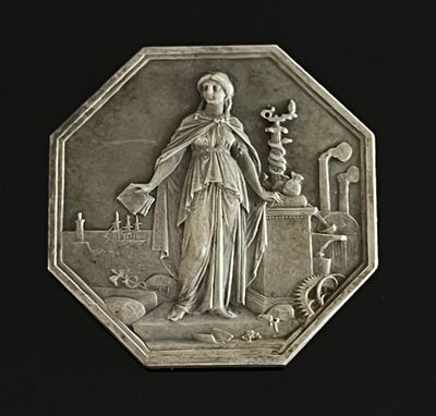 un médaillon en argent représentant une femme tenant une fleur
