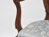 a wooden chair with a blue upholstered cushion on it