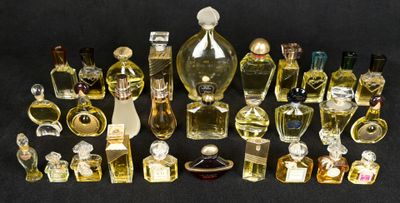 de nombreux flacons de parfum de toutes sortes posés sur une surface noire