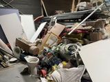 a pile of junk in a room with a toilet and other items