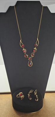un gros plan d'un collier et de boucles d'oreilles exposés sur une table