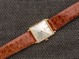 une photo d'une montre en or avec un bracelet en cuir marron