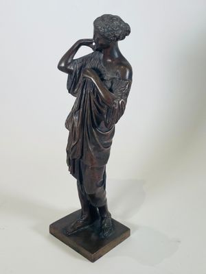 statue en bronze représentant une femme tenant une fleur dans la main droite