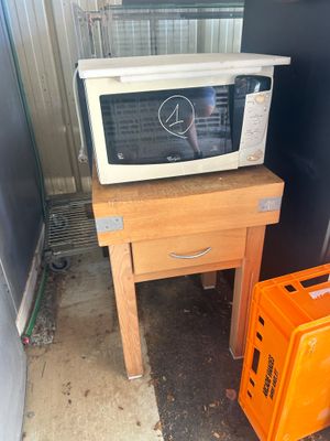a microwave sitting on top of a table next to an orange crate