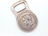 a bottle opener with a coin on it on a white surface