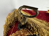 a close up of a red and gold purse with a metal handle