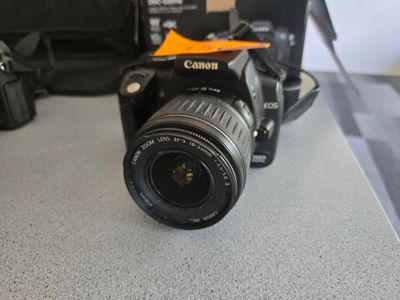 a camera sitting on a counter next to a bag