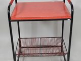 an image of a red and black metal shelf with a shelf underneath it