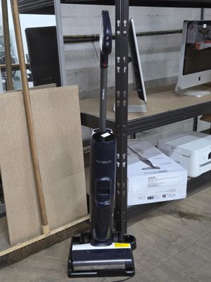 un aspirateur posé sur un support dans une pièce