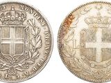 a silver coin with a coat of arms and a crown on it
