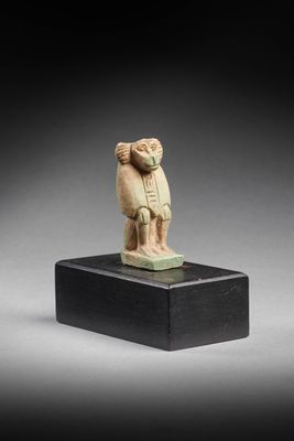 une figurine égyptienne sculptée représentant un homme tenant un oiseau