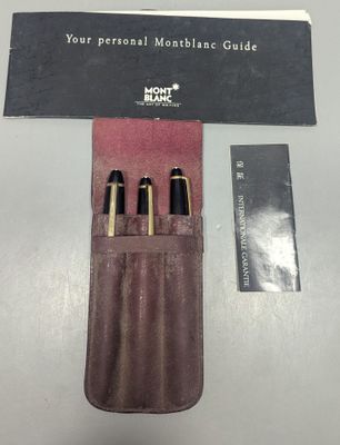trois stylos dans un étui en cuir posé sur une table
