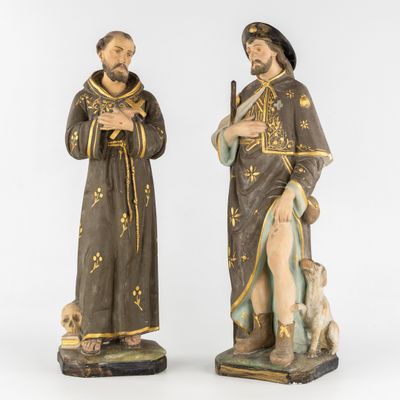 two statues of a man and a woman with a dog
