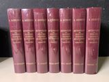 six livres rouges sur une étagère, avec un mur noir en arrière-plan