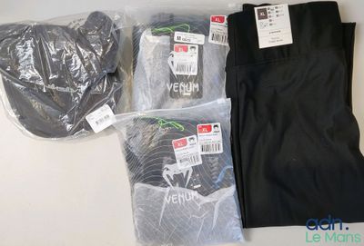 Deux paires de pantalons noirs et un pantalon noir sont posés sur une table