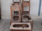several wooden chairs stacked on top of each other in a room