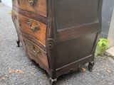 une commode ancienne sur roulettes devant un immeuble