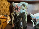two vases sitting on a table with a drawer in the background