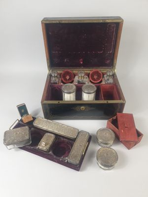une image représentant une boîte contenant des couverts et d'autres objets posée sur une surface blanche