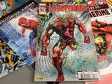 many comic books on a table with a spider - man in the background