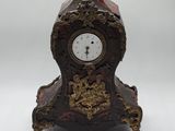 une petite horloge posée à côté d'une petite pièce de monnaie