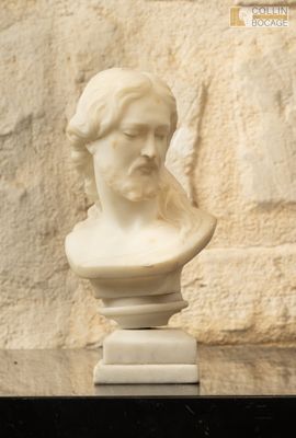 un buste d'homme en marbre blanc posé sur une table
